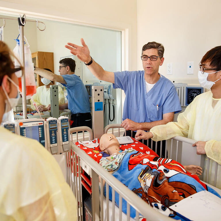 professor gestures to nursing students in immersive learning space
