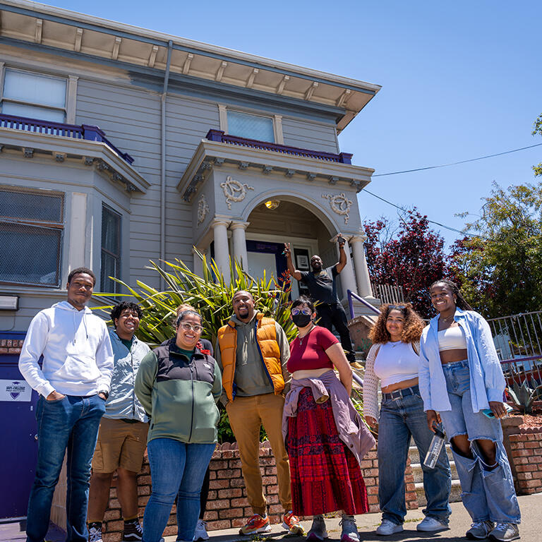 group of students stand in front of a victorian building in san francisco