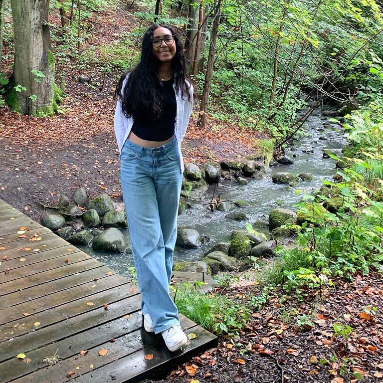 Student in front of a creek outside Copenhagen