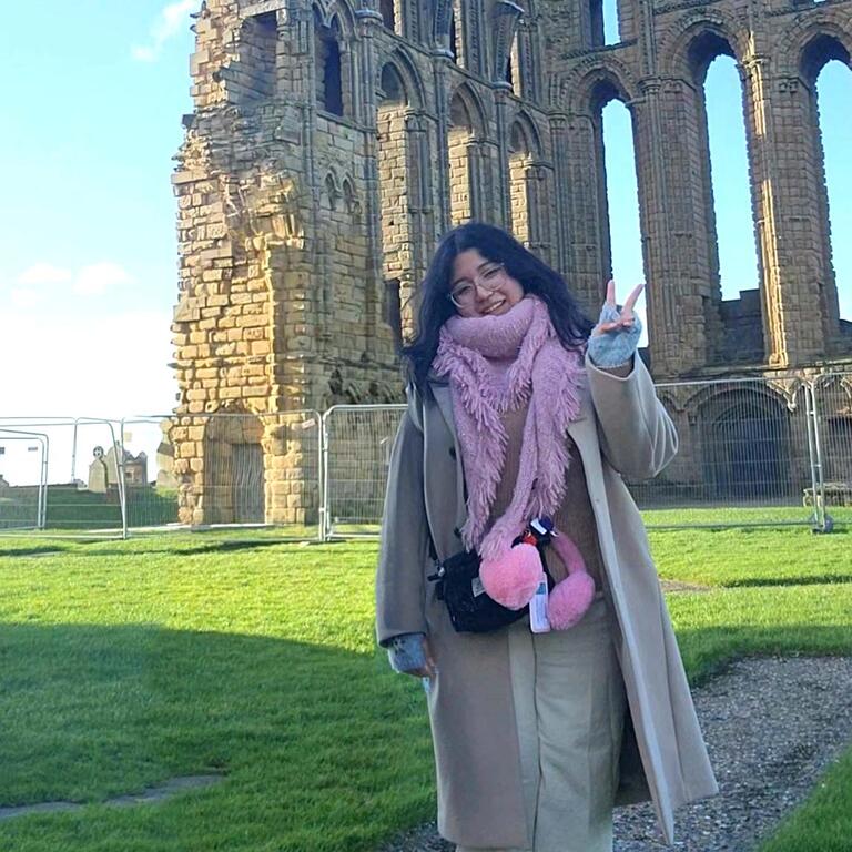 Study abroad student poses near ruins in UK.