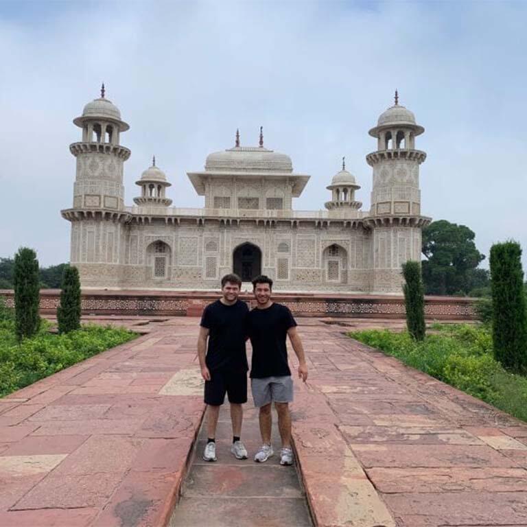 Two students standing in front of a building in India