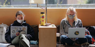 Students with laptops study on couches in the lounge in UC.