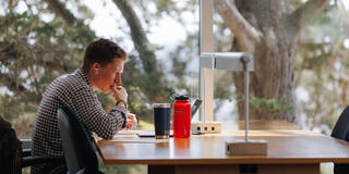 Student studies at a table in the library.