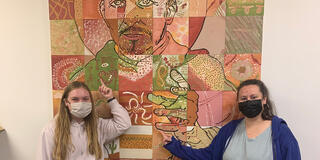 Two students in front of the Saint Ignatius mural