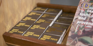 Matchboxes with "divest from your self" written on them.