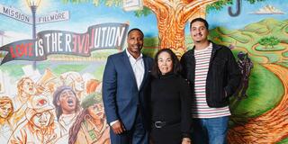 Derrick Brown and Leslie Lombre stand in front of the Leo T. McCarthy Center mural