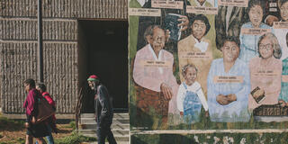 People walking in front of a mural