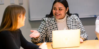 student speaking to another student in class