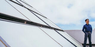 Christopher Mihm standing near solar panels