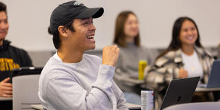 USF student in class listening and laughing about something professor said