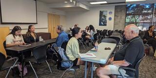 Students sitting at tables with adults