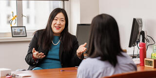 two people talk to one another across table
