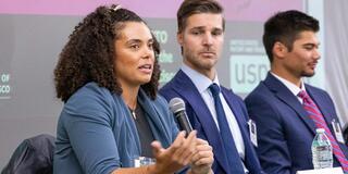 Three students speaking on a panel
