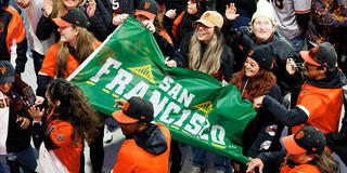 usf community members hold san francisco banner during giants game
