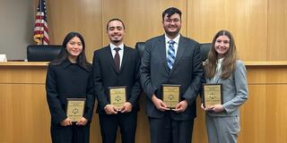 Four people standing in the moot court