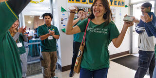 students cheering on new freshman as they move into their dorms