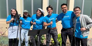 Group of ASUSF members standing and smiling with microphones