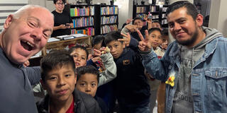 John Omernik (left) shares a moment with students during a visit to the Little Spanish English School
