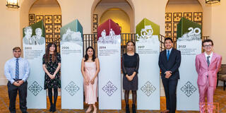 Six students standing next to the McCarthy Center's 20-year milestones