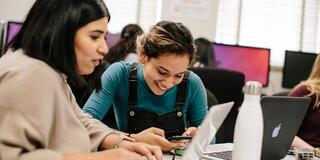 Two students work on their laptops