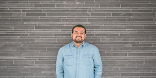 Student stands in front of wall