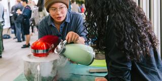student pouring water into a dry ice exhibit