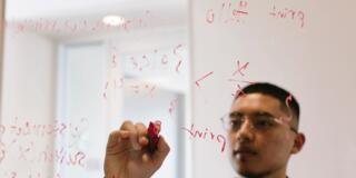 student working on clear whiteboard