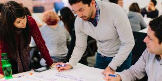 Three students work on presentation in School of Management