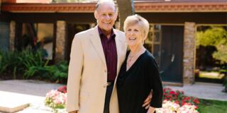 John A. and Susan Sobrato pose in front of building