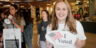 Student holds a large 'I Voted' sign