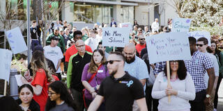 USF faculty, staff, and students holding signs and marching for Sexual Assault Awareness Month.