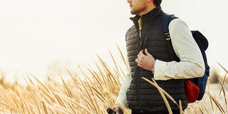 Student stands in a field of tall grass