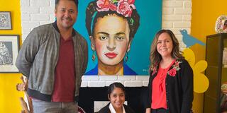 Three people posting in front of a painting