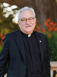 Fr Fitzgibbons poses for a photo outside