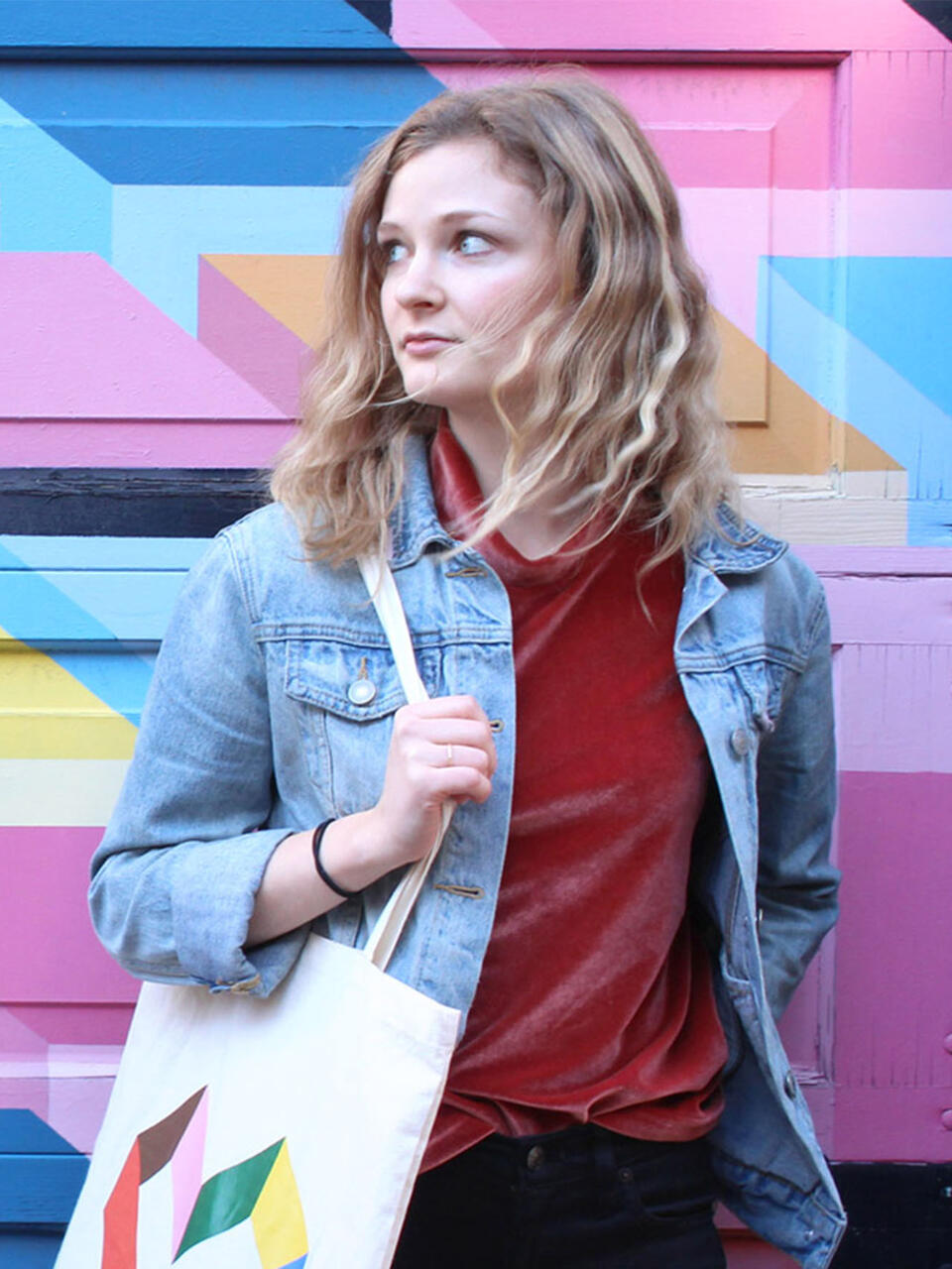 Madeline Warner in front of a mural.