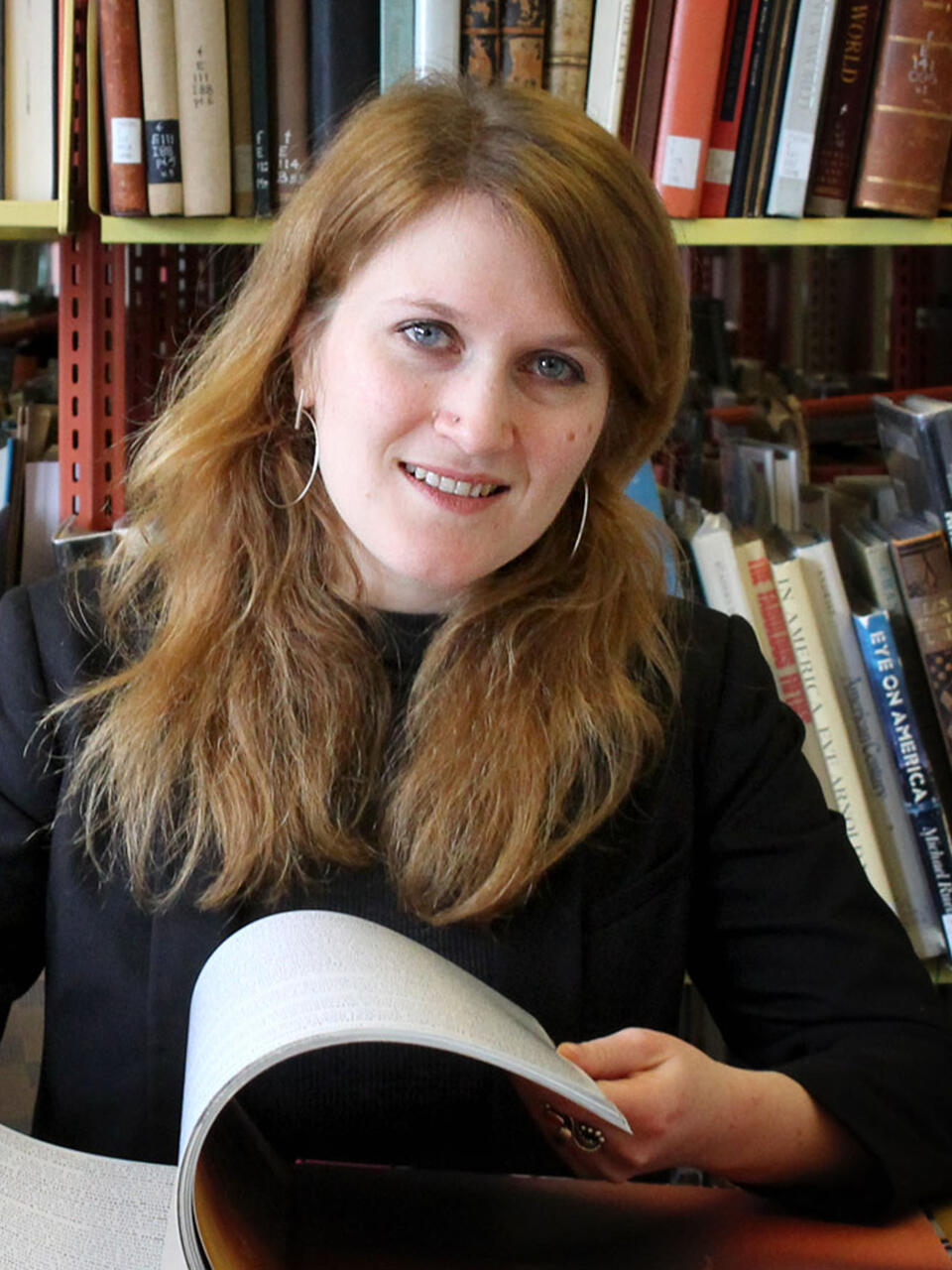 Aubree Mladenovic looks at books in the library.