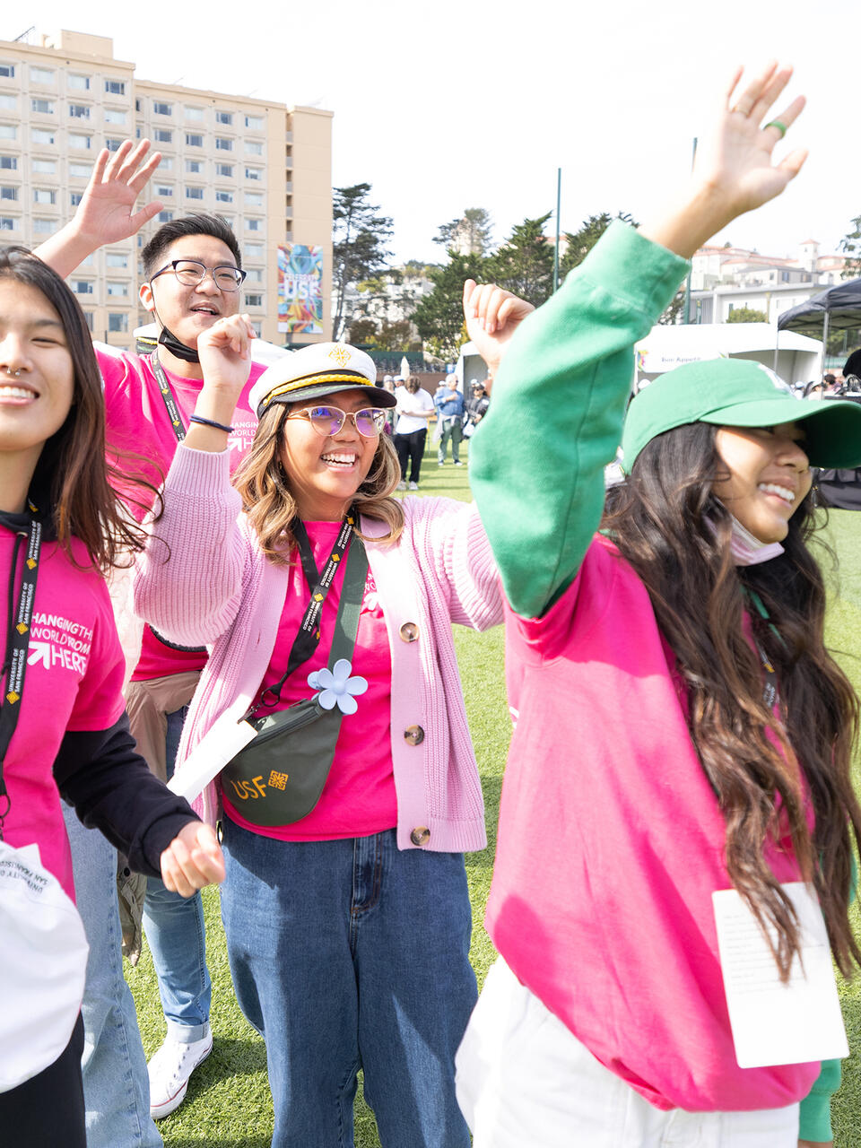 students laughing and raising their arms in the air