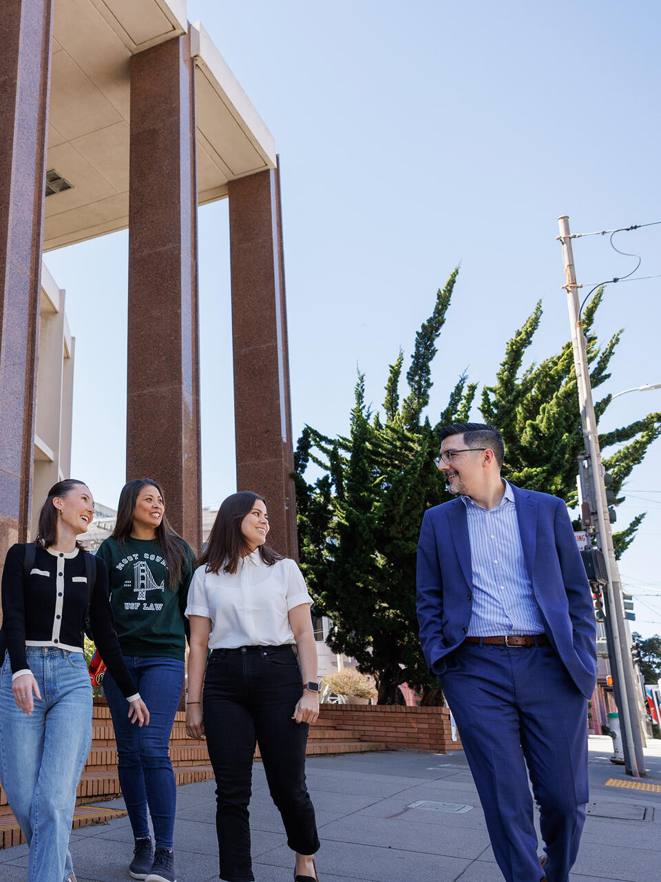 students walk with professor on usf campus