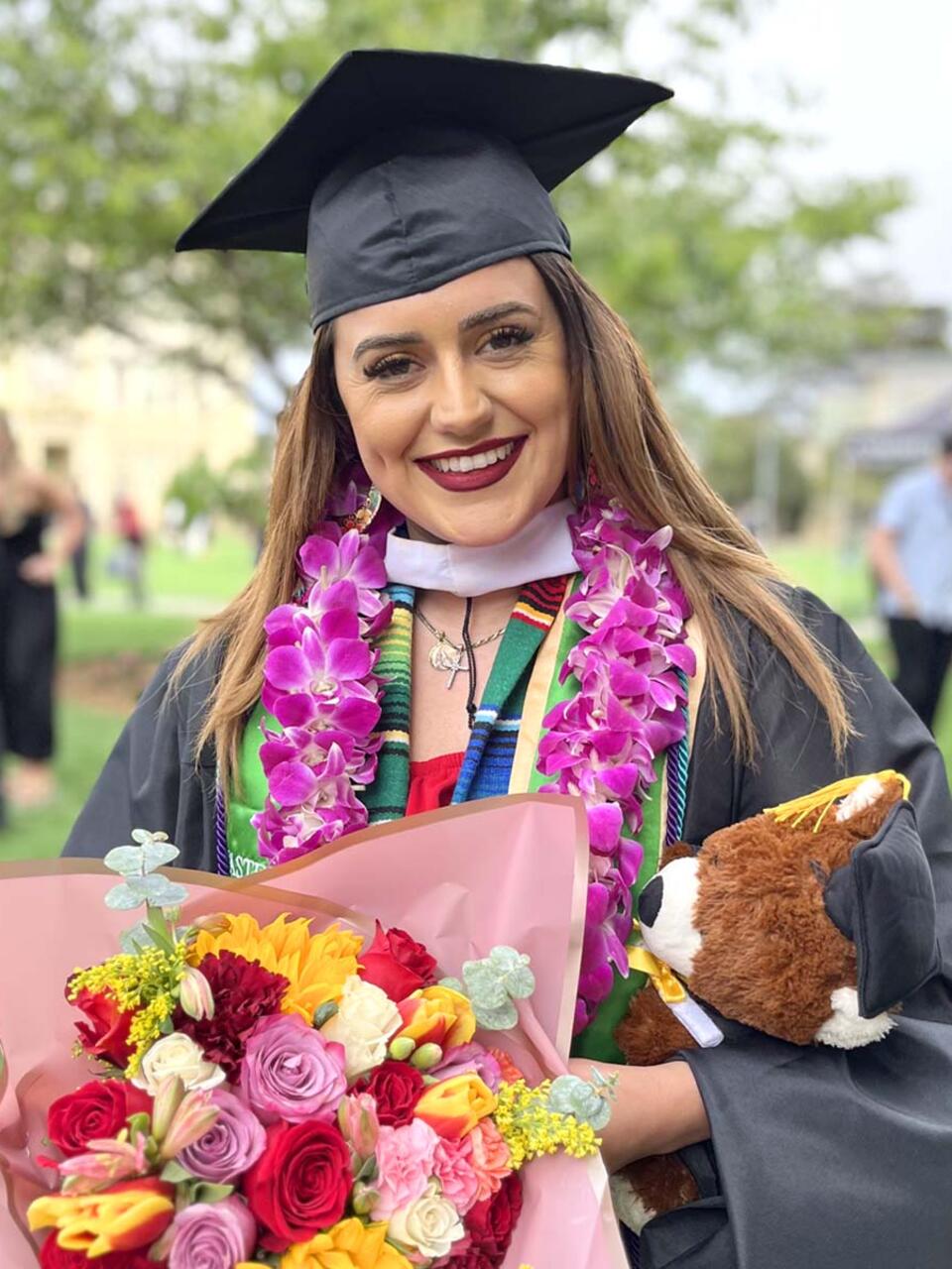 Maria Membrila holding flowers after graduating.