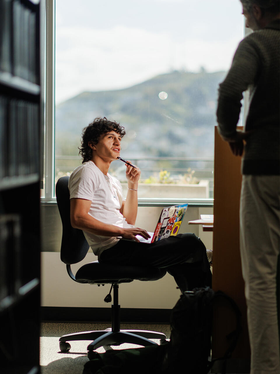 Student chatting with a peer in the law library