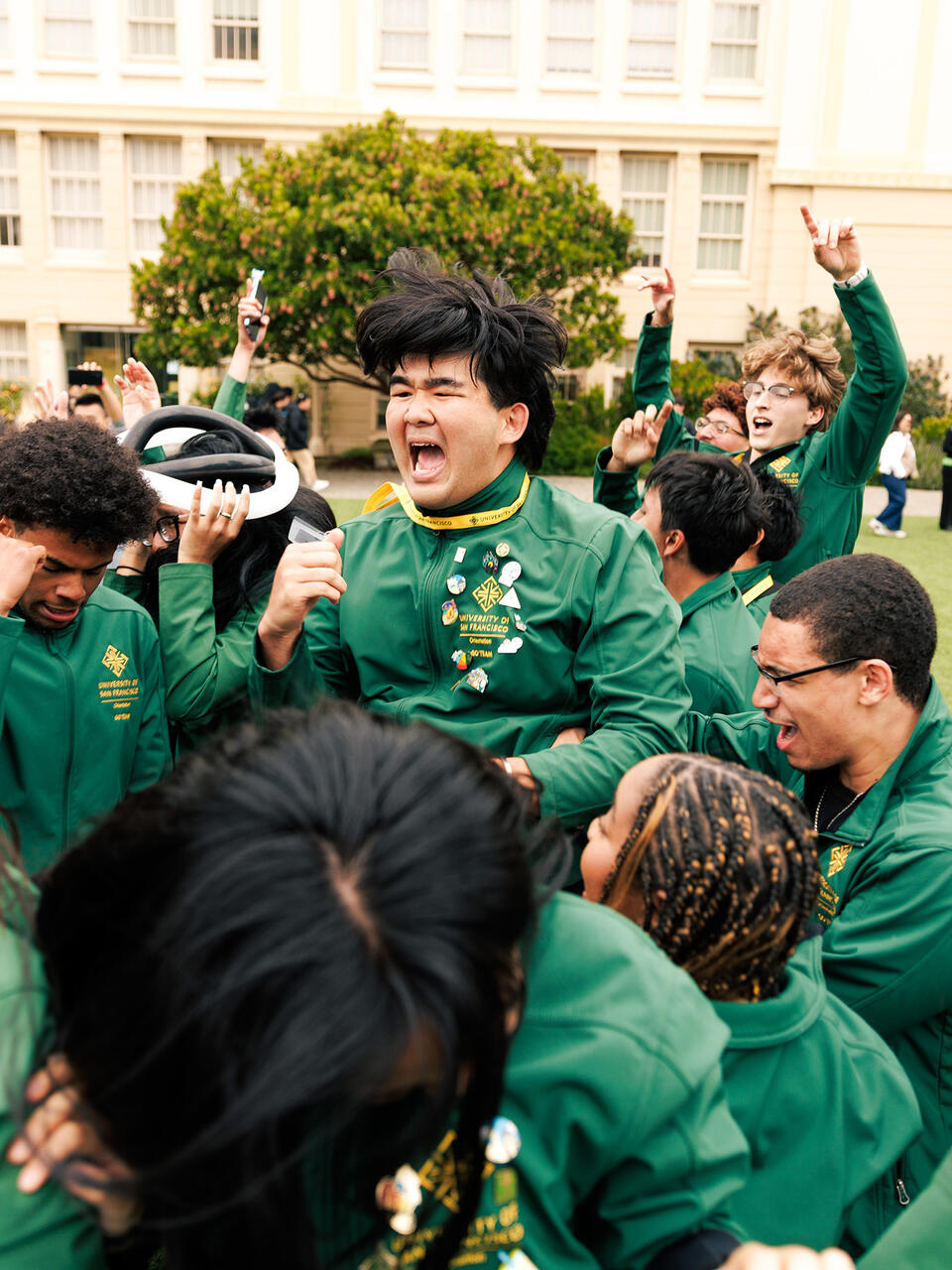 usf students dressed in green jumping up and down outside