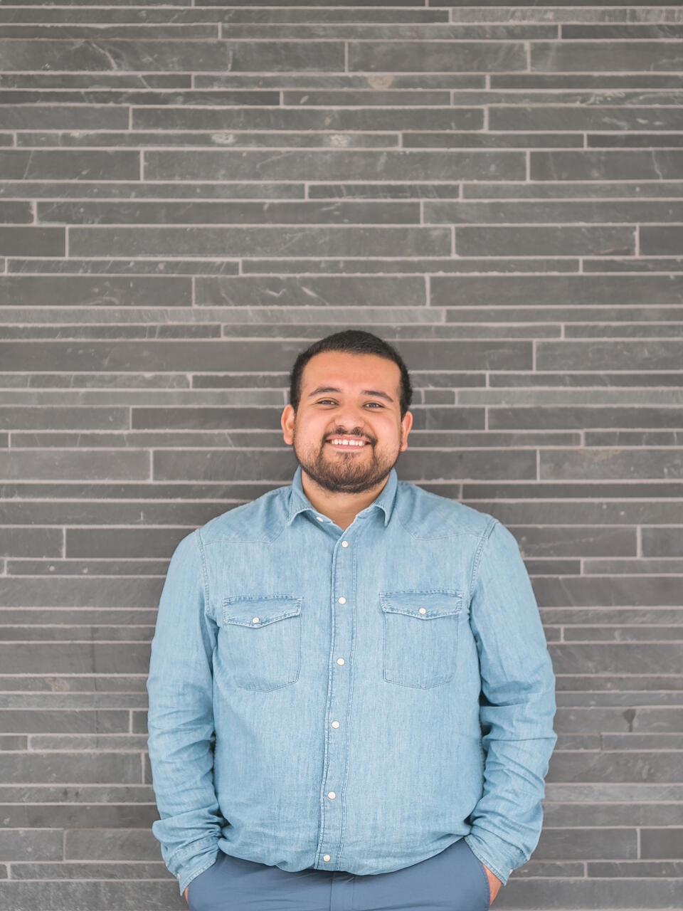 Student stands in front of wall